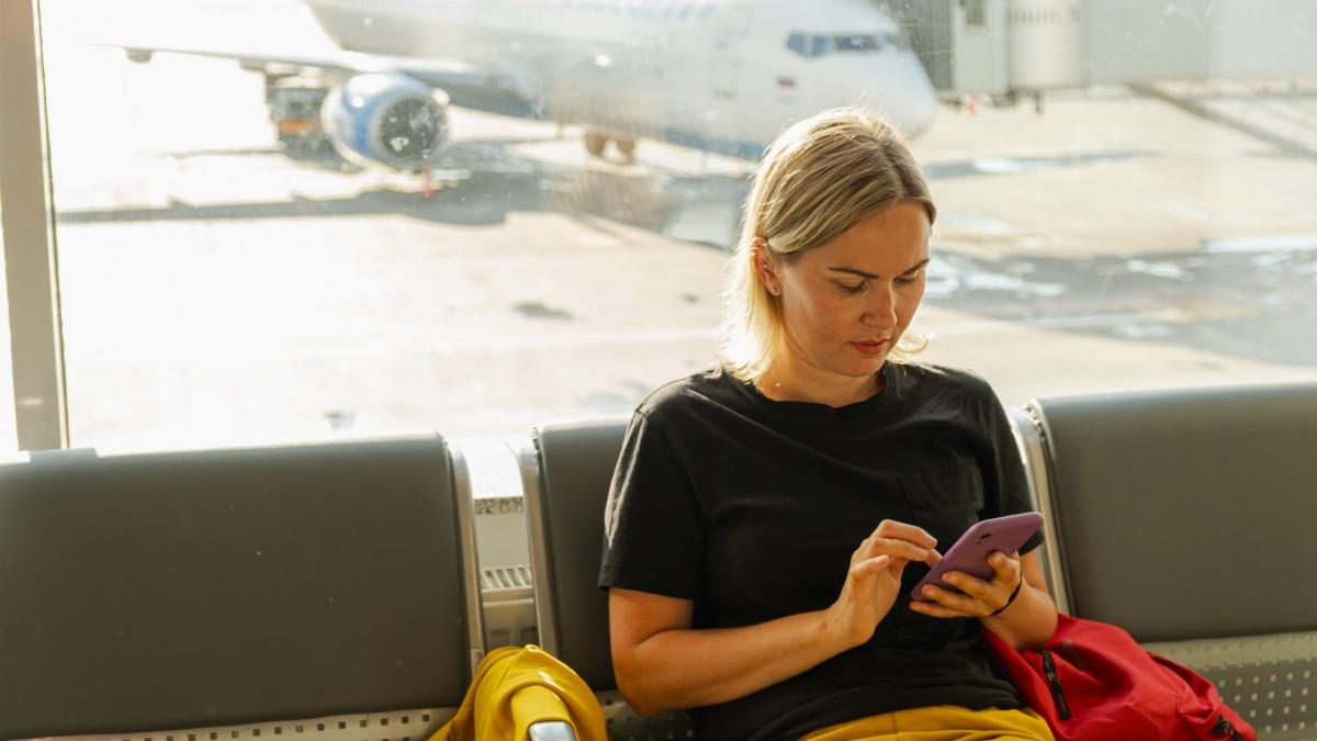 femeie care sta pe telefon in aeroport