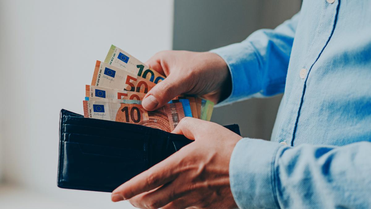 bărbat scoate bacnote de euro din portofel