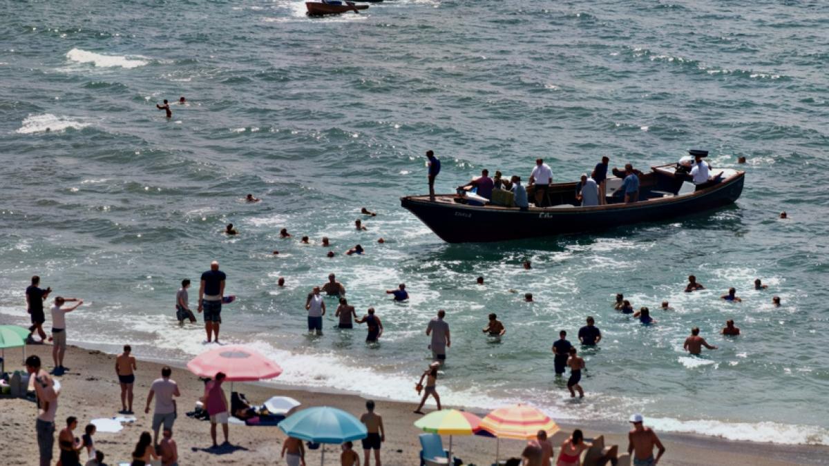 turistii de pe o plaja din spania au luat o la fuga cand 60 de migranti cu o barca au luat cu asalt locul
