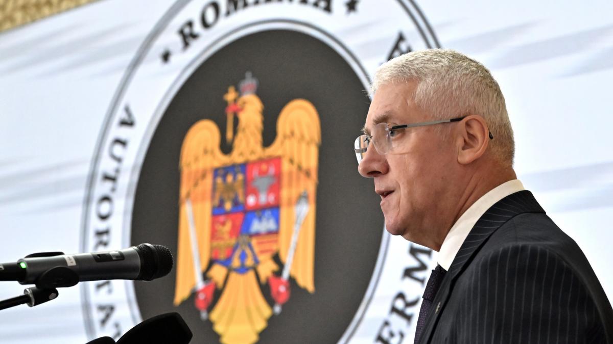 barbat cu ochelari din profil la microfon