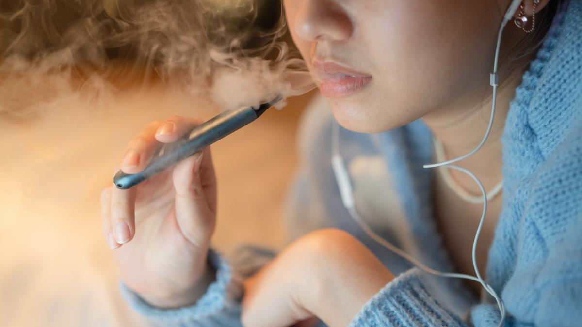 femeie cu țigară electronică in mana fumând