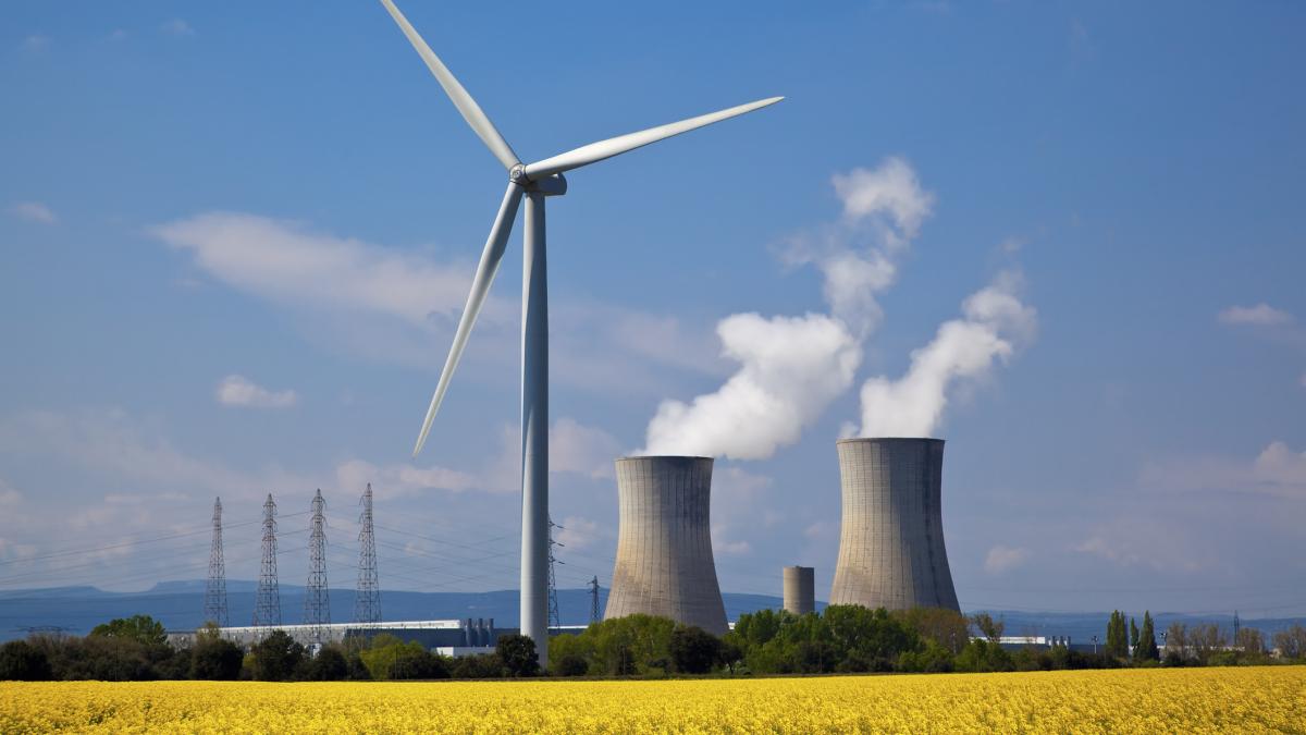 poza in care apar o centrală nucleară și oturbină eoliană

