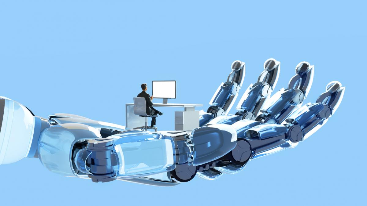 om la birou stă în palma unei mâini robotice.