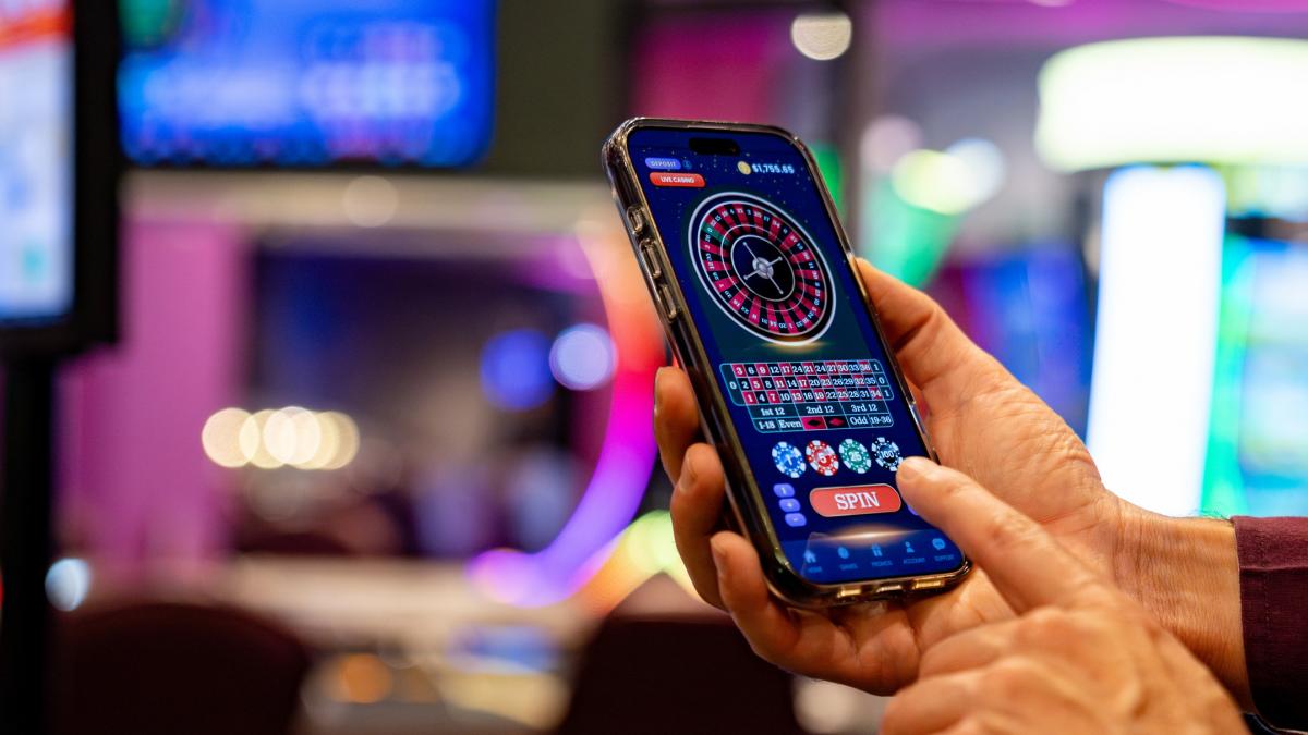 bărbat cu telefon in mana jucând la cazino online 