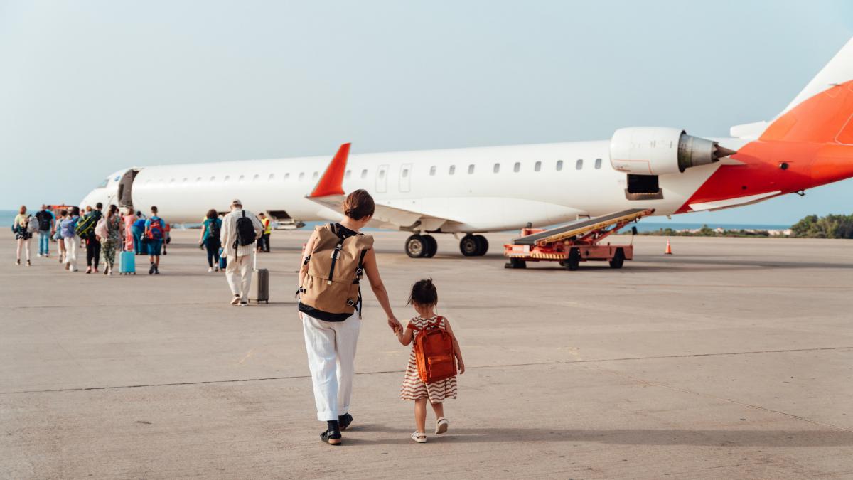 turiști merg spre un avion