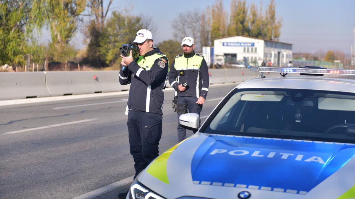 politist care sta cu aparatul radar in mana si masoara viteza soferilor