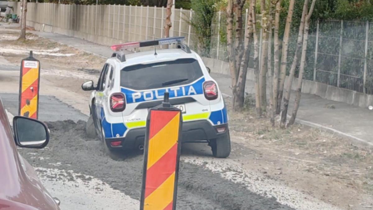 mașină de poliție blocată în beton proaspăt turnat.