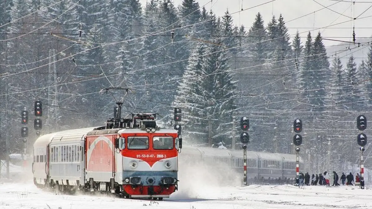 tren mergand pe un traseu din zona de munte iarna