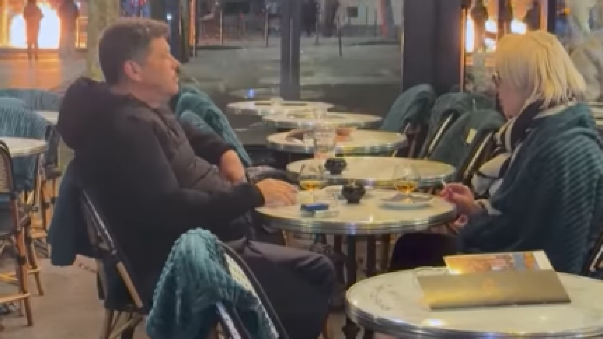 un cuplu bea linistit langa arcul de triumf in vreme ce parisul arde imaginile au facut inconjurul lumii