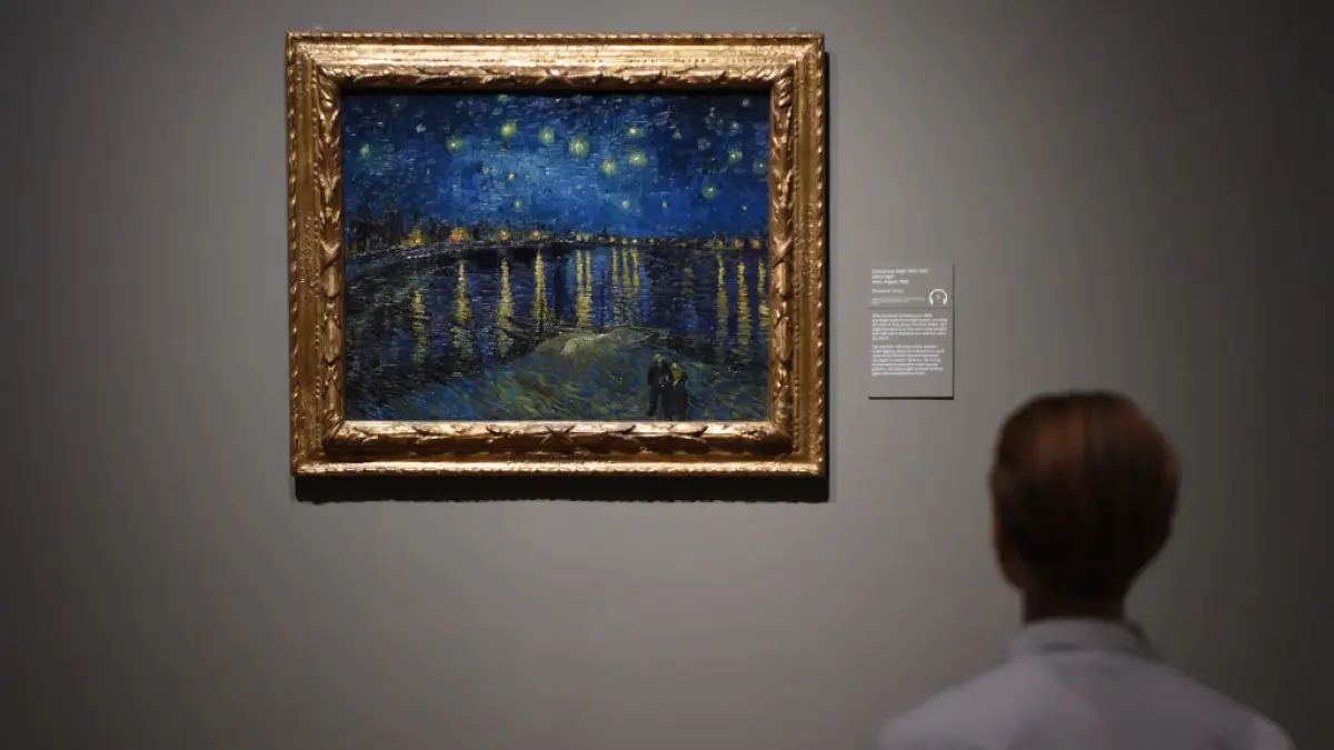 Un barbat priveste tabloul „Noaptea înstelată” al lui Van Gogh 