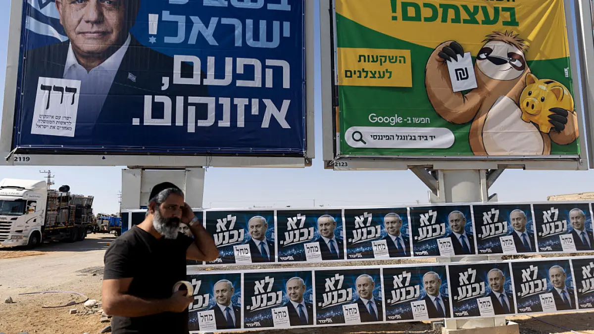 un bărbat trece prin fața unui panou electoral în Israel