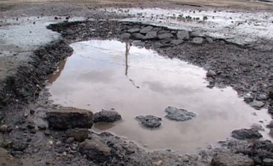 Craterele de pe drumurile româneşti fac victime. Un camion şi un taxi au rămas blocate în gropi pline cu apă