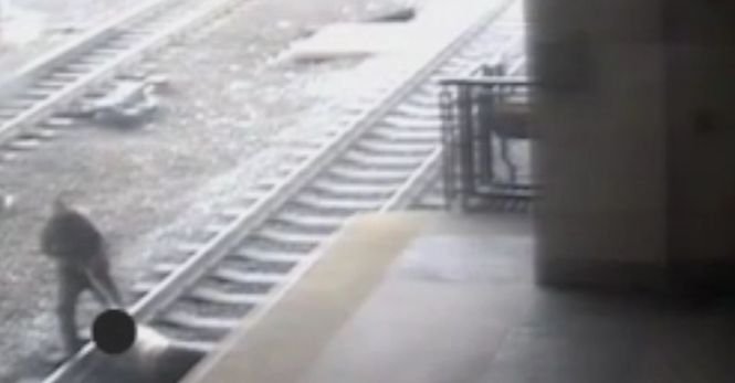 Un polițist a devenit erou după ce a salvat un om de pe calea ferată. Imaginile surprinse cu câteva momente înainte de trecerea trenului - VIDEO
