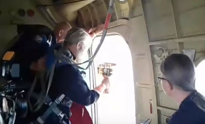 Un preot a aruncat apă sfințită din elicopter peste locuitori. Vrea să-i vindece de „beție și desfrâu” - VIDEO