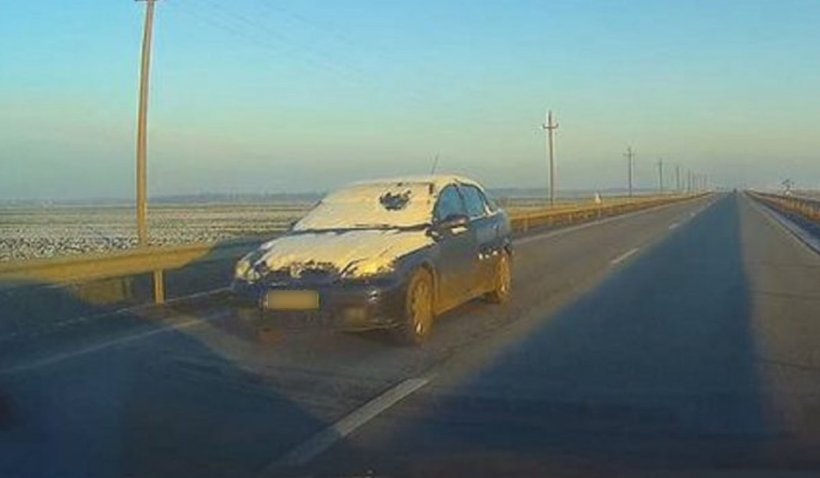 Şofer kamikaze surprins circulând cu parbrizul acoperit de zăpadă, pe un drum naţional din România