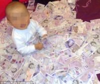 Un hoţ român din Marea Britanie şi-a pozat copilul pe un maldăr de bancnote furate