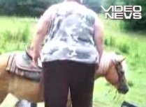 O femeie supraponderală încearcă să se urce pe un căluţ (VIDEO)