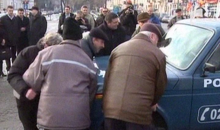 Scandal la Arad: Revoluţionarii au mutat o maşină de poliţie care bloca înălţarea drapelului