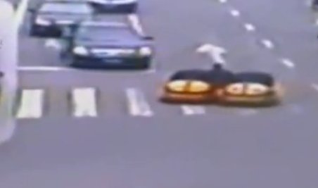 China. Un bărbat conduce simultan două maşinuţe prin traficul aglomerat