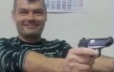 Distracţie cu arma din dotare: Un poliţist a postat pe internet poze în care apare cu două pistoale