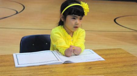 O fetiţă născută fără mâini a câştigat un concurs de caligrafie 143270