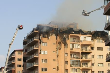Locatarii blocului afectat de incendiu stau la coadă pentru a primi cazare la hotel 