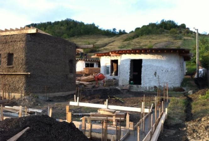 Mini-sat cu locuinţe eco, în apropierea Vulcanilor Noroioşi. Casele sunt făcute din lut, au ferestre din parbrize şi acoperişuri cu iarbă