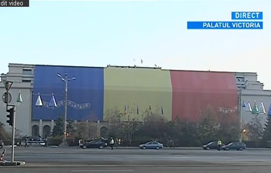 Tricolor uriaş descoperit pe frontispiciul clădirii Palatului Victoria, de Ziua Naţională a României