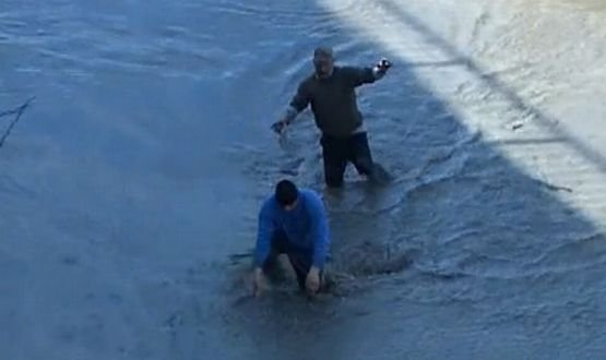 Pescuit extrem în Argeş. Zeci de oameni s-au tăvălit prin noroi pentru a aduna peştele dintr-un baraj golit de apă