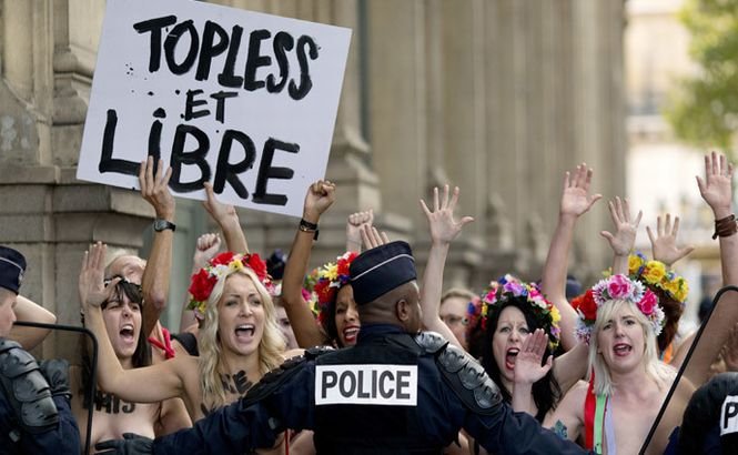 Activistele FEMEN au protestat şi au fugit de poliţiştii din Paris. Unul dintre ei a fost &quot;intimidat&quot; şi a căzut în faţa fetelor pe jumătate goale