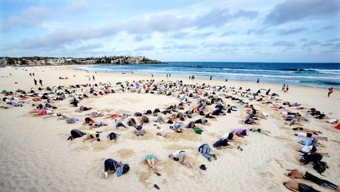 Sute de oameni şi-au băgat capetele în nisip, protestând faţă de ignorarea încălzirii globale la G20