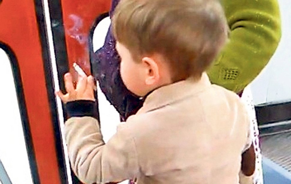 Un copil de 3 ani fumează cu o maturitate şocantă într-un tramvai. Mama şi călătorii îi încurajează gestul