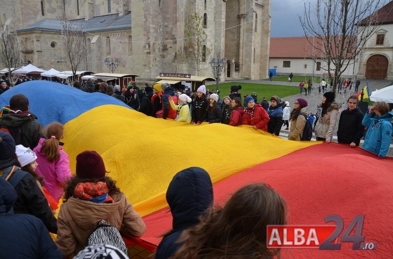Ziua Naţională a României. Drapel uriaş purtat pe braţe prin Cetatea Alba Carolina
