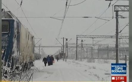 Imagini uluitoare pe o cale ferată din România. Pasagerii, obligaţi să meargă pe jos în viscol