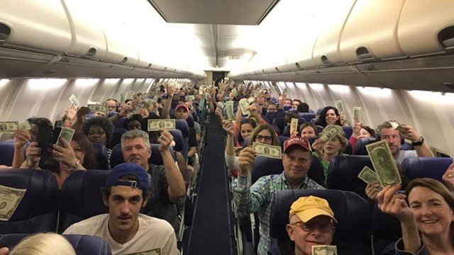 Întâmplare inedită într-un avion! Un bărbat s-a ridicat și a început să împartă bancnote tuturor pasagerilor. Când au aflat de ce face asta, toți au început să plângă