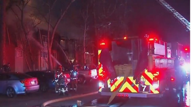 Intervenție dramatică! Momentul în care un pompier prinde un copil aruncat din clădirea cuprinsă de flăcări - VIDEO
