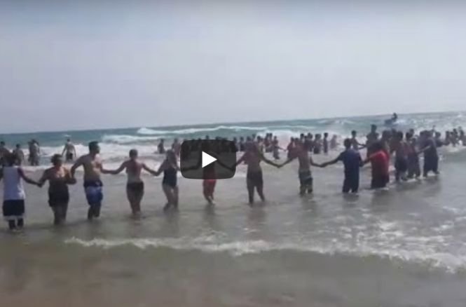 Toți care erau pe plajă au format un lanț uman și au intrat așa în apă, cu zecile! Ce s-a întâmplat după câteva minute e incredibil - VIDEO