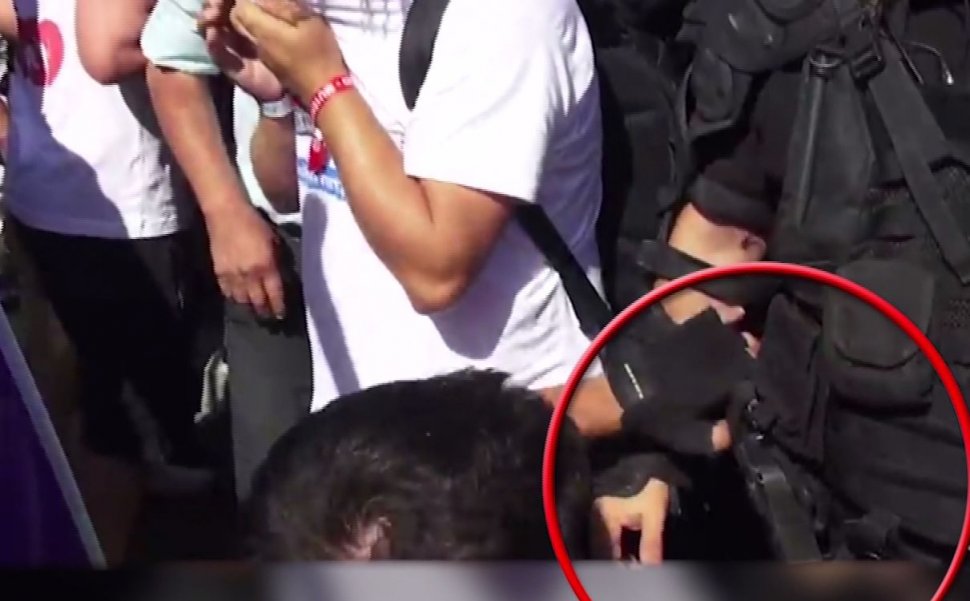 Imaginile care aduc adevărul la suprafață. Un protestatar, surprins cu mâna pe arma jandarmului, la protestul din Piața Victoriei