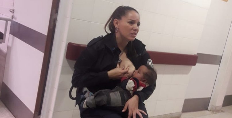 Poza cu o politista care hraneste la piept un copil a devenit virala. Motivul e dureros!