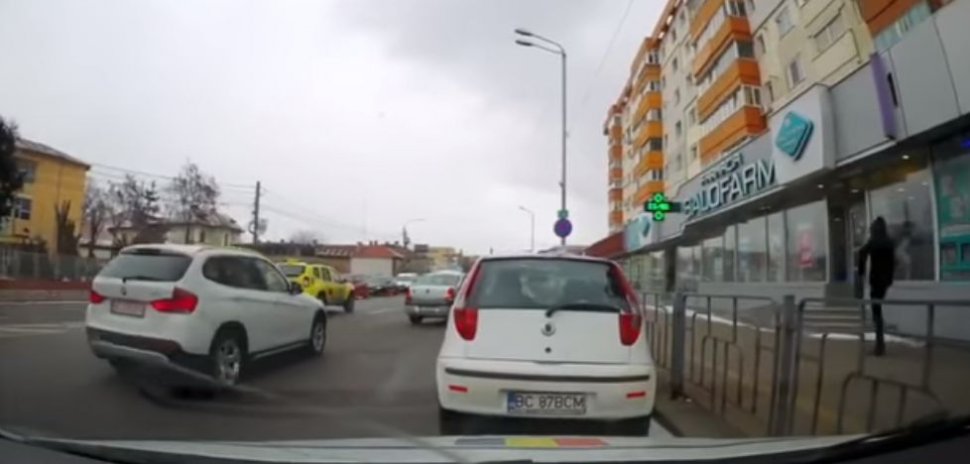 Imagini incredibile suprinse în centrul Bacăului! Polițistul a oprit circulația, după care s-a aplecat să se uite sub o mașină. Totul a fost filmat (VIDEO)