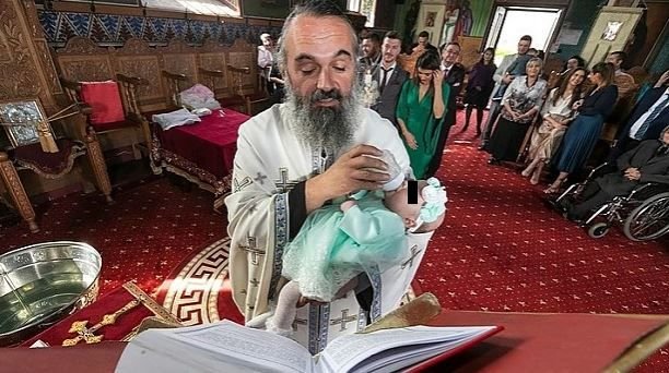 Moment înduioșător la botezul unei fetițe. Preotul Iustin Milu a luat bebelușul care plângea și l-a hrănit cu biberonul, în timp ce-i citea o rugăciune
