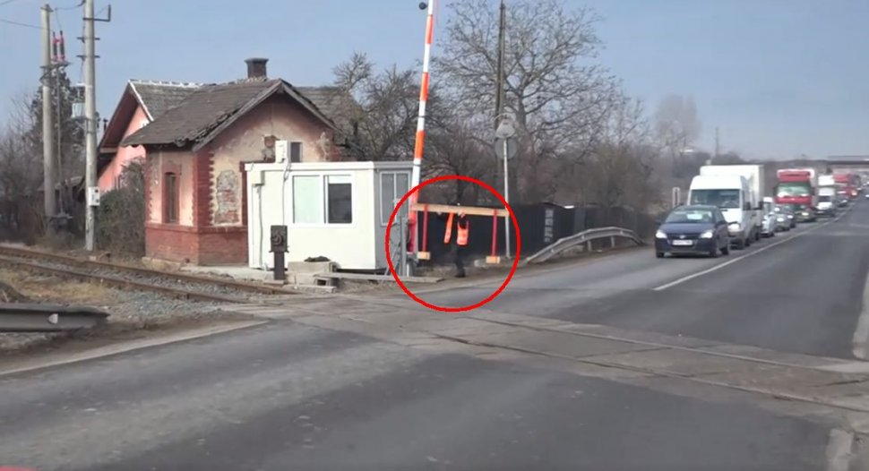 O angajată CFR cară în spate barierele de la trecerea peste calea ferată, la Hunedoara. Șoferii sunt nevoiți să aștepte zeci de minute  - VIDEO