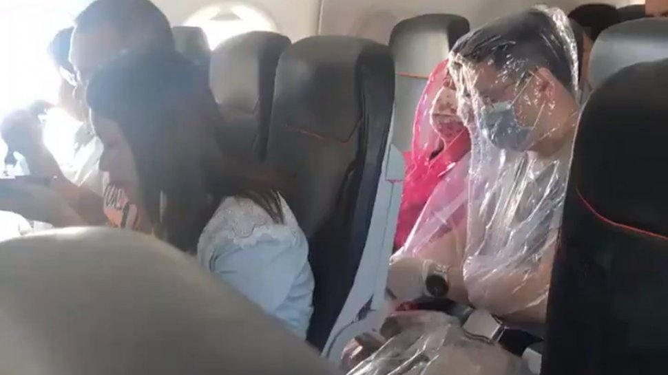 Pasagerii unui avion s-au înfășurat în plastic, la propriu, de frica de coronavirus. Imagini virale!