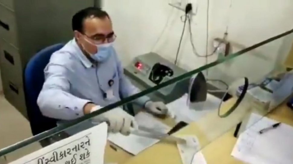 Cum se protejeză suplimentar un casier de la o Bancă din India de coronavirus cu două instrumente casnice