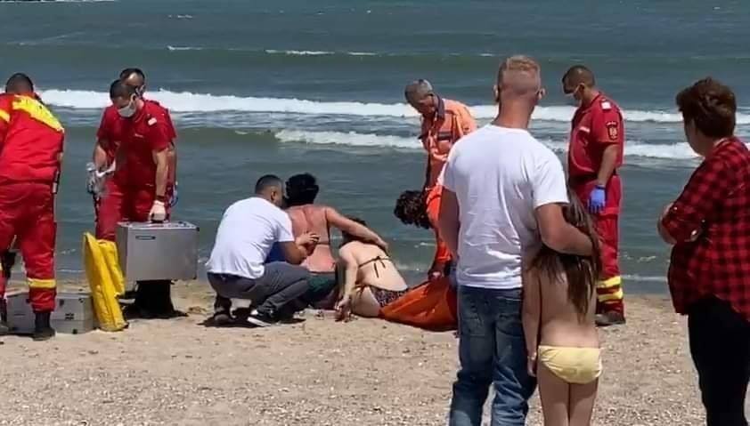 O femeie îşi plânge bărbatul înecat în mare, la Neptun. O fată a rămas orfană de tată