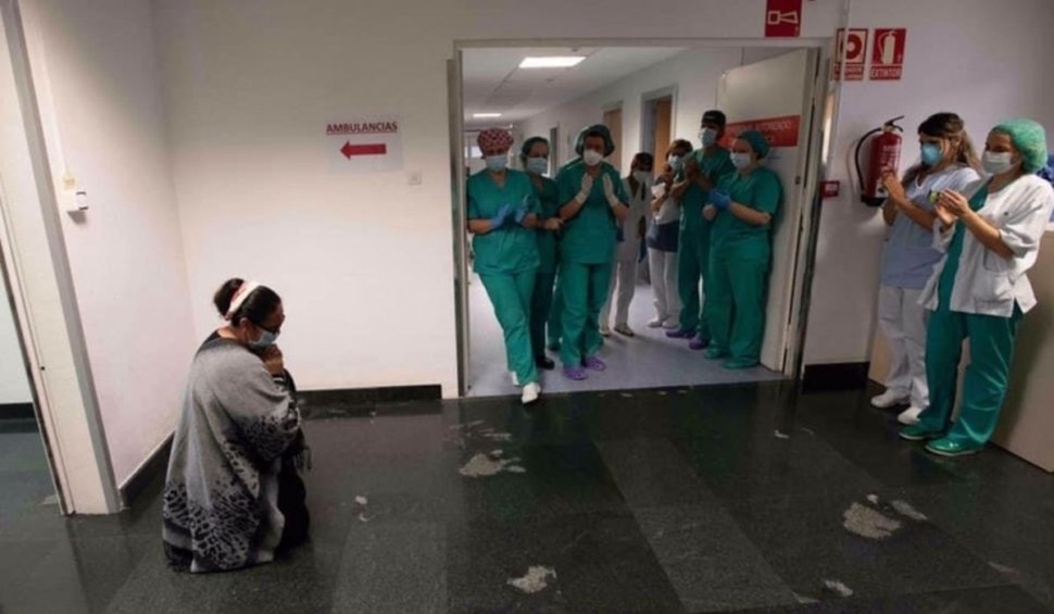 Poza anului în Spania. Mamă româncă, în genunchi în fața medicilor care i-au salvat fiul bolnav de COVID