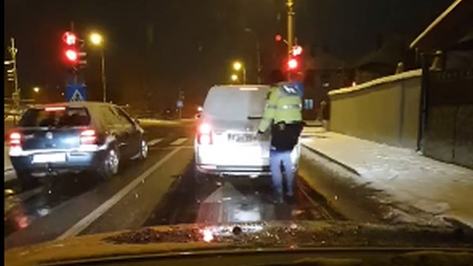 Un poliţist din Sibiu a deszăpezit luneta unui şofer, la un semafor din oraş