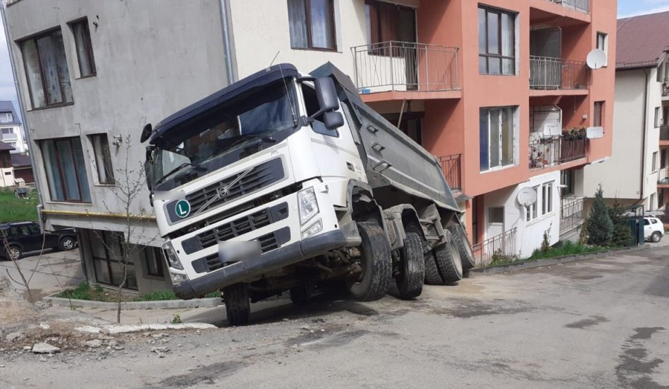 O basculantă cu 30 de tone de nisip s-a răsturnat peste parterul unui bloc, în judeţul Cluj