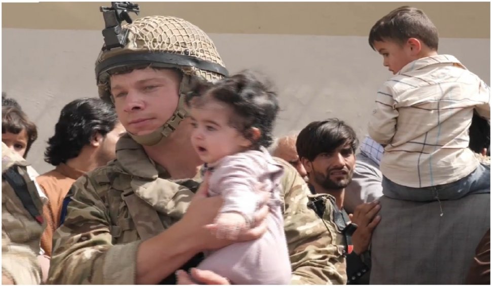 Mamele disperate îşi aruncă copiii peste gardul de sârmă ghimpată la Kabul, implorând soldații să îi salveze