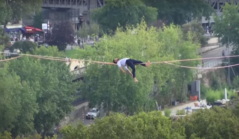 Acrobație la nivel înalt. Francezul Nathan Paulin s-a culcat pe coarda întinsă la 70 de metri înălțime, între Turnul Eiffel și Piața Trocadero